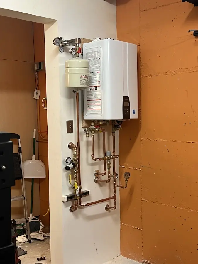 Plumbing technician inspecting water heater connections in Rainbow Lakes Estates